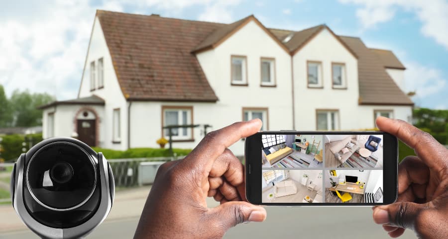 Man holding mobile device and checking streams from surveillance cameras